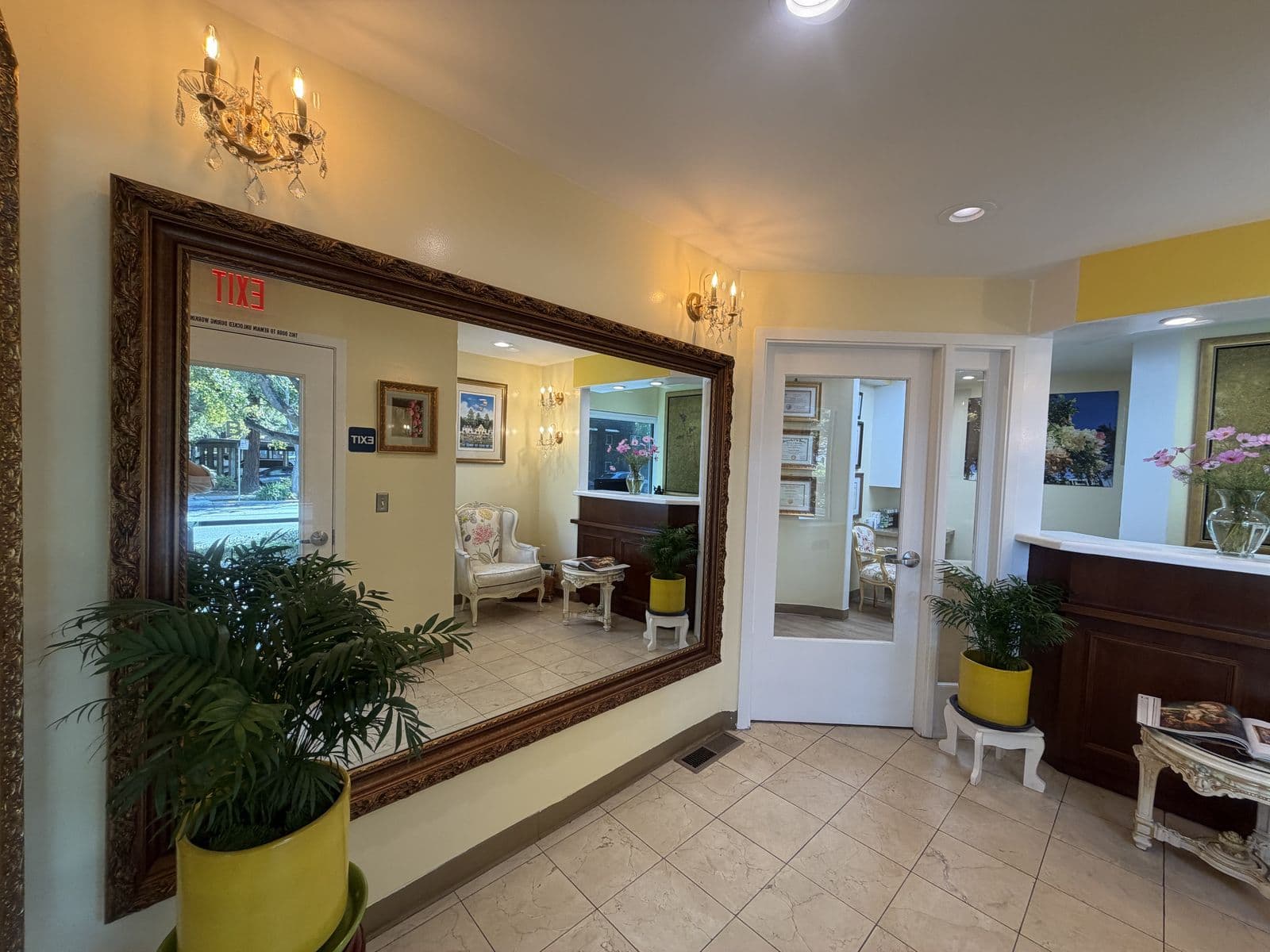 Waiting room with a large framed mirror and plants